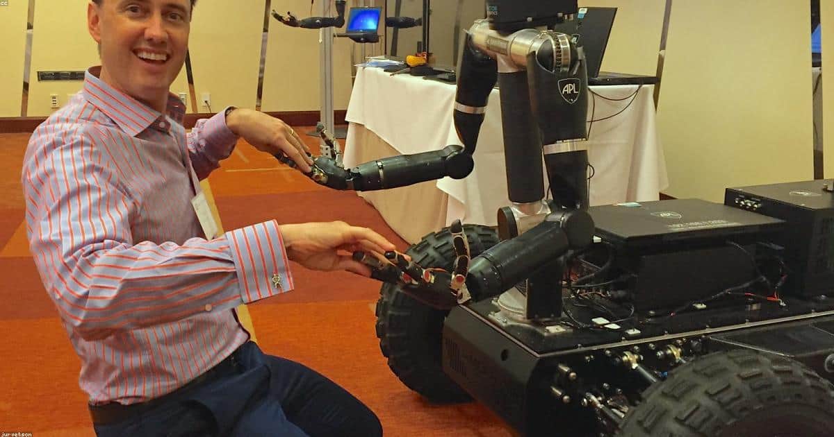 Man and robot shaking hands representing human-AI collaboration