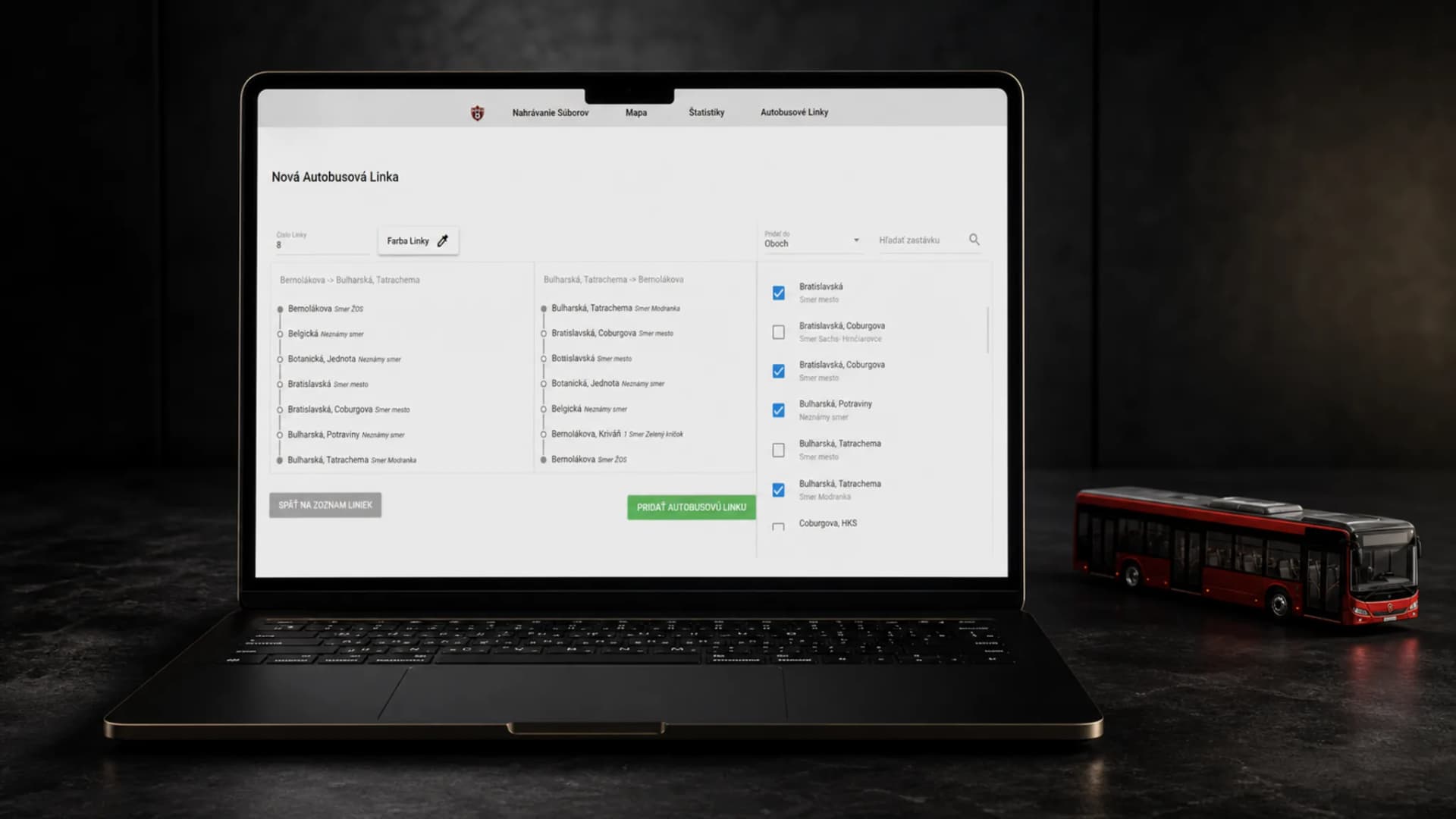 Editor autobusovej linky na MacBooku vedľa červeného modelu autobusu